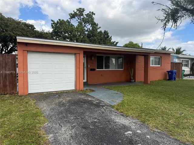 a front view of house with yard and trees in the background