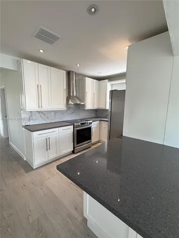 a kitchen with stainless steel appliances a refrigerator sink and stove