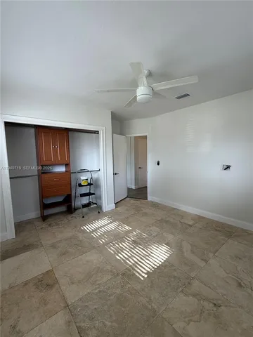 a view of empty room with furniture and ceiling fan