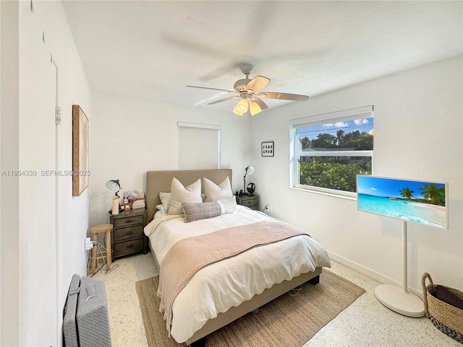 640 Southwest 6th Street Hallandale Beach, FL 33009 - Photo 12 of 18 a bedroom with a bed chandelier and a window
