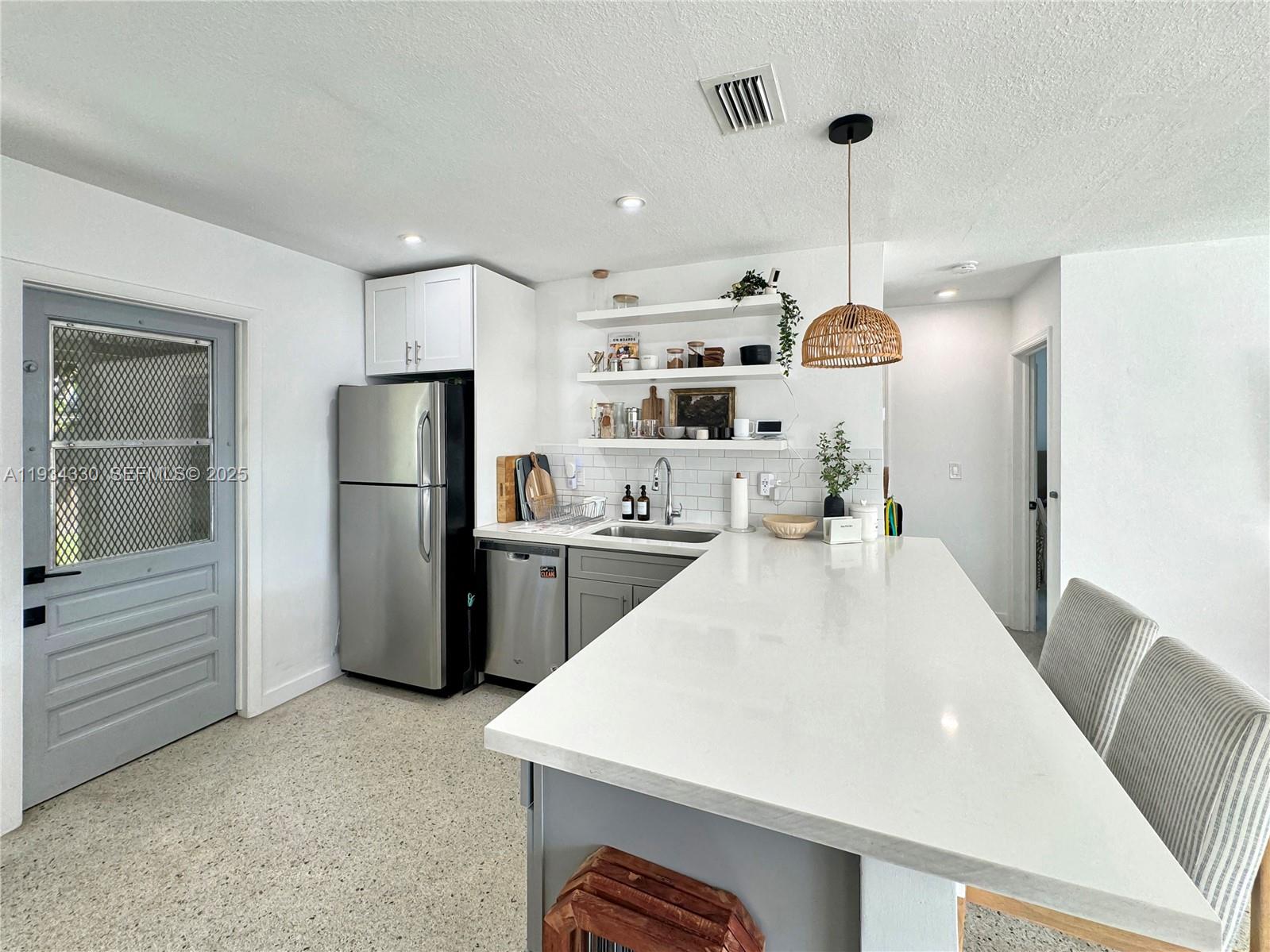 640 Southwest 6th Street Hallandale Beach, FL 33009 - Photo 9 of 18 a large white kitchen with a refrigerator a sink and a stove