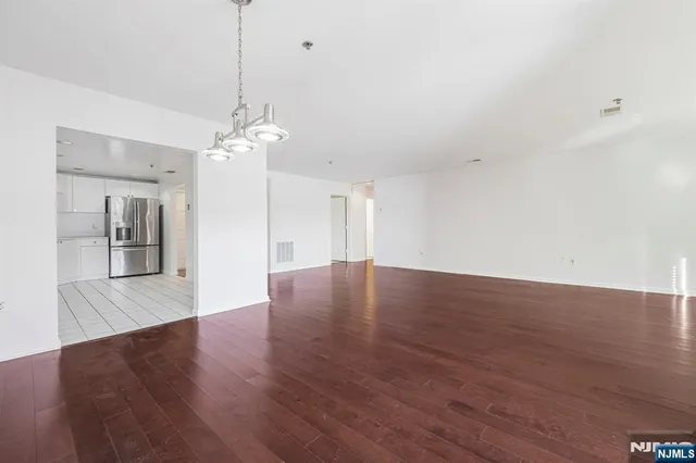 a view of a livingroom with wooden floor and a ceiling fan