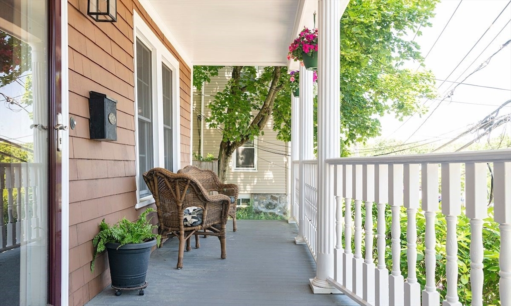 a view of a porch with chairs and potted plants