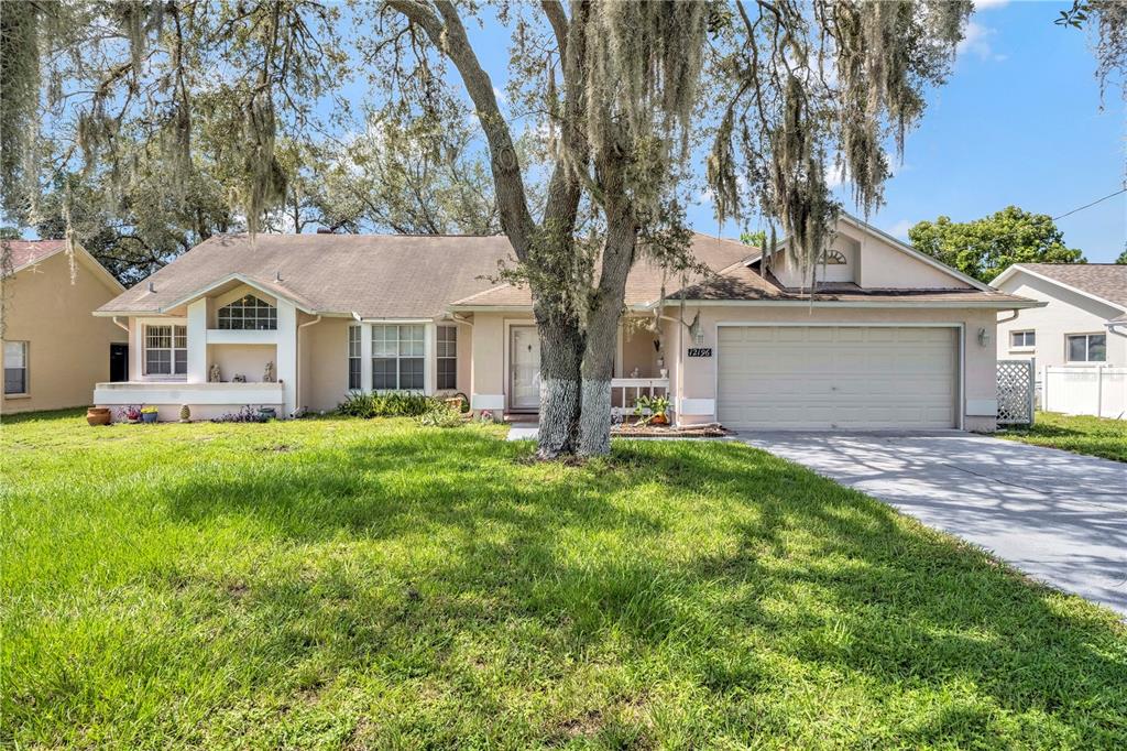 a front view of a house with a garden and trees