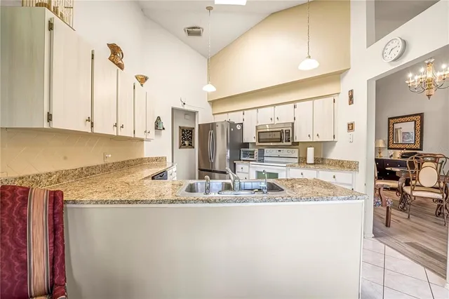 a kitchen with stainless steel appliances granite countertop a sink refrigerator and cabinets
