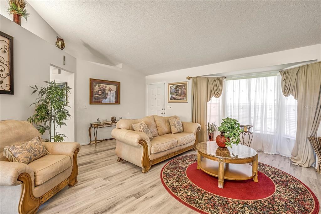 12196 Bluefield Street Spring Hill, FL 34609 - Photo 3 of 47 a living room with furniture or couch and a potted plant