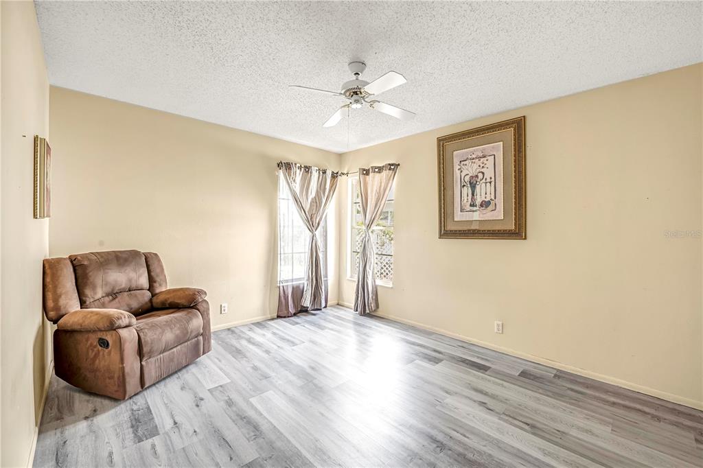12196 Bluefield Street Spring Hill, FL 34609 - Photo 35 of 47 a living room with furniture and a ceiling fan