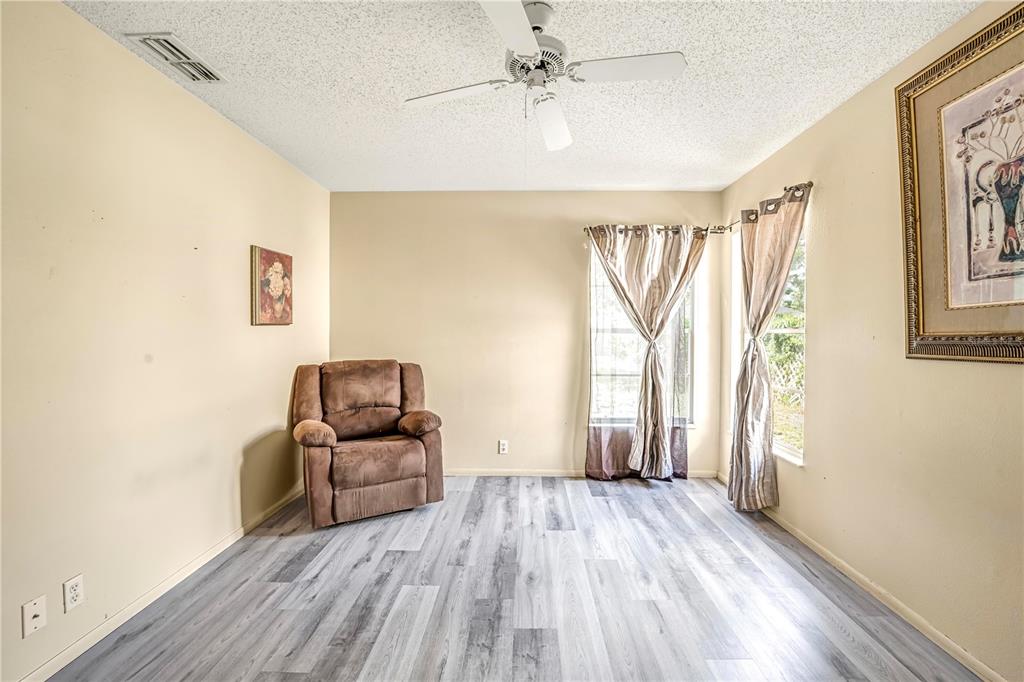 12196 Bluefield Street Spring Hill, FL 34609 - Photo 36 of 47 a living room with furniture and a wooden floor