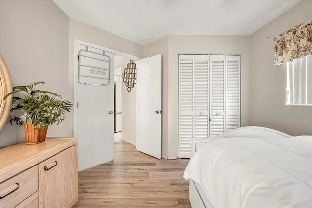 a bedroom with a bed potted plant with the wooden floor