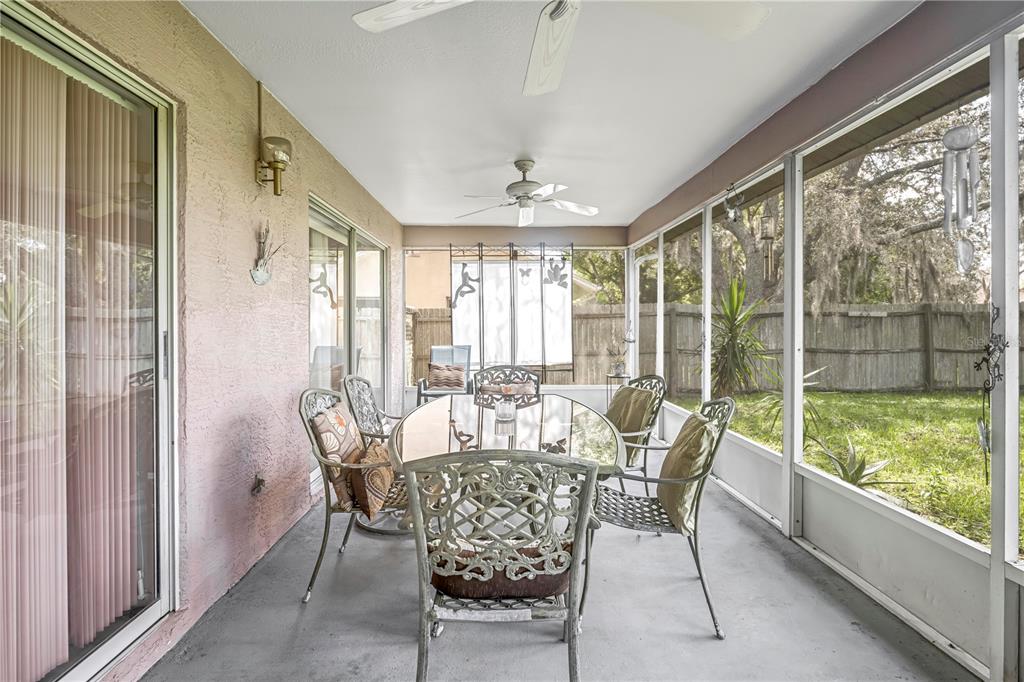 12196 Bluefield Street Spring Hill, FL 34609 - Photo 43 of 47 a dining room with furniture large windows and wooden floor