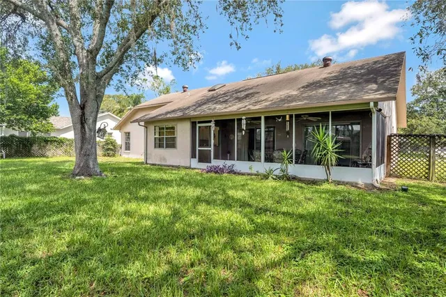 a view of a house with backyard garden and sitting area