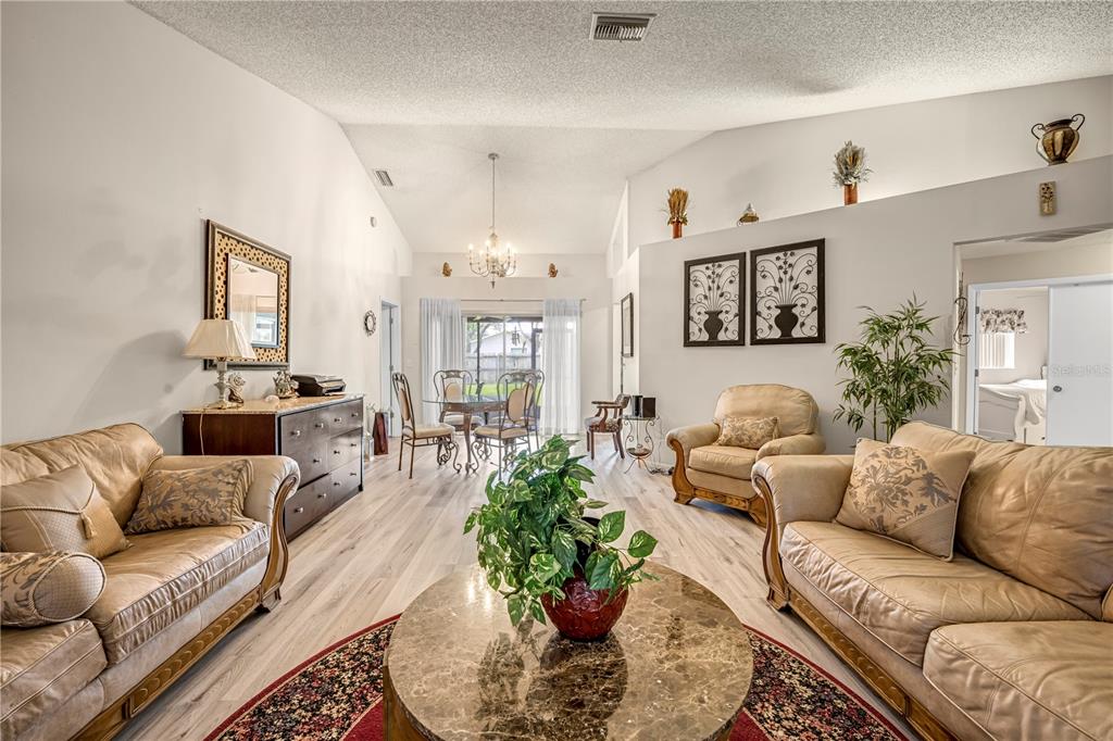 12196 Bluefield Street Spring Hill, FL 34609 - Photo 9 of 47 a living room with furniture potted plant and a window