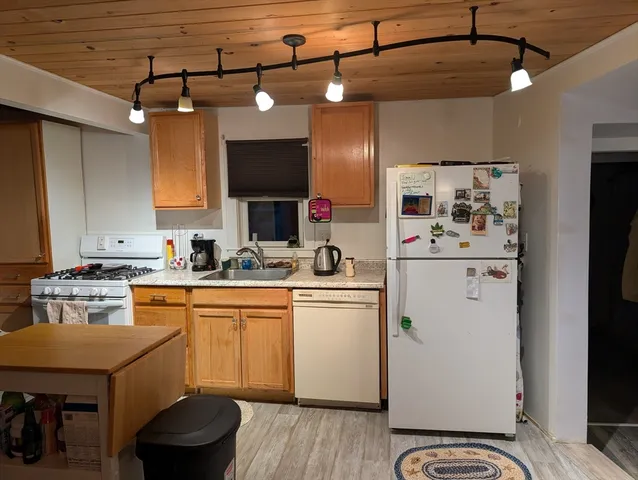 a kitchen with a sink cabinets and wooden floor