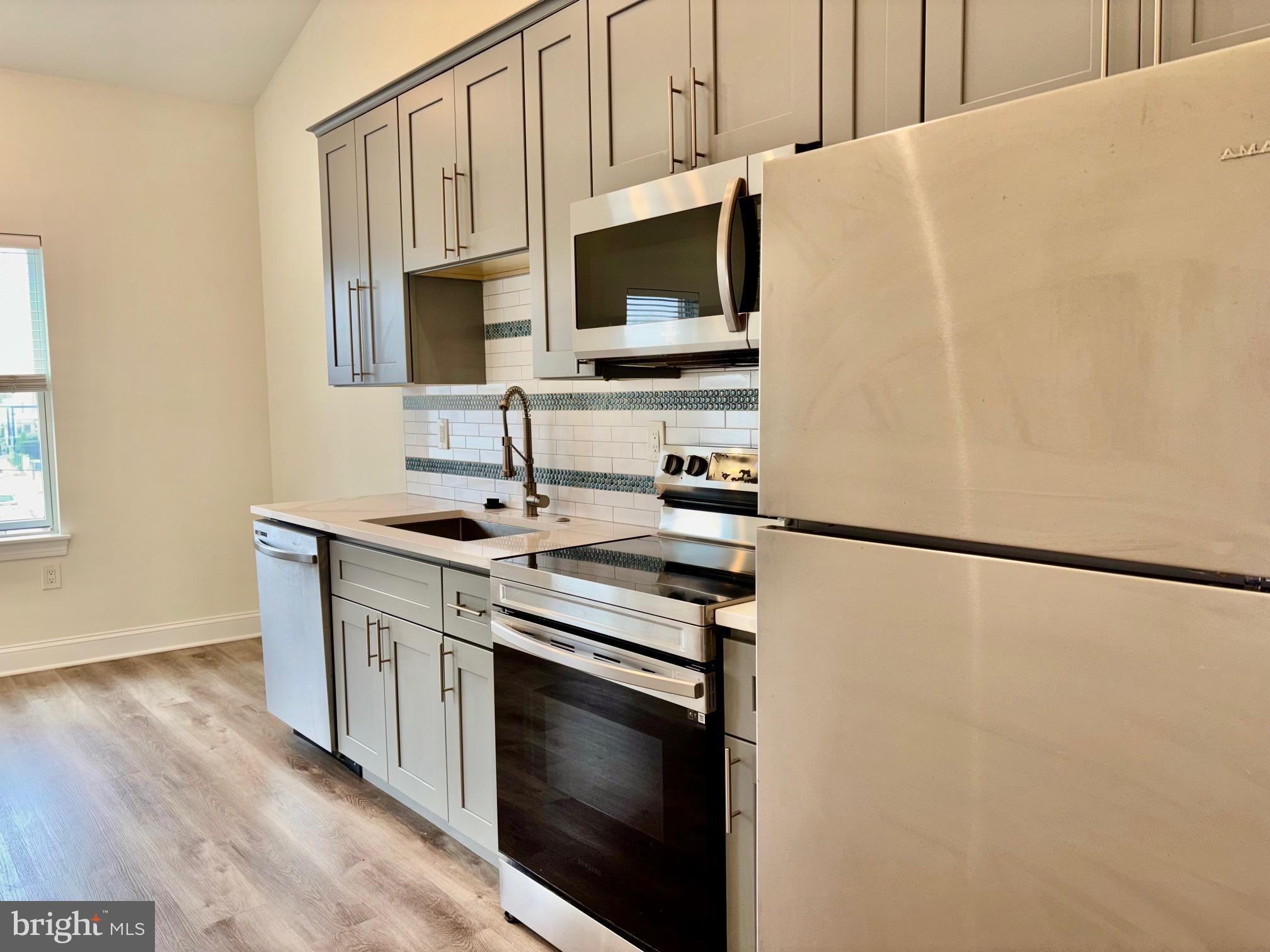 6601 Ridge Avenue, Unit D Philadelphia, PA 19128 - Photo 1 of 10 a kitchen with stainless steel appliances a refrigerator stove and microwave