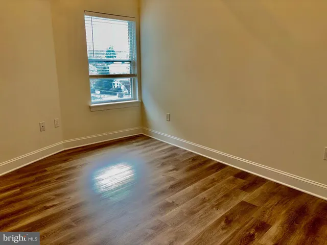 a view of a room with wooden floor and window