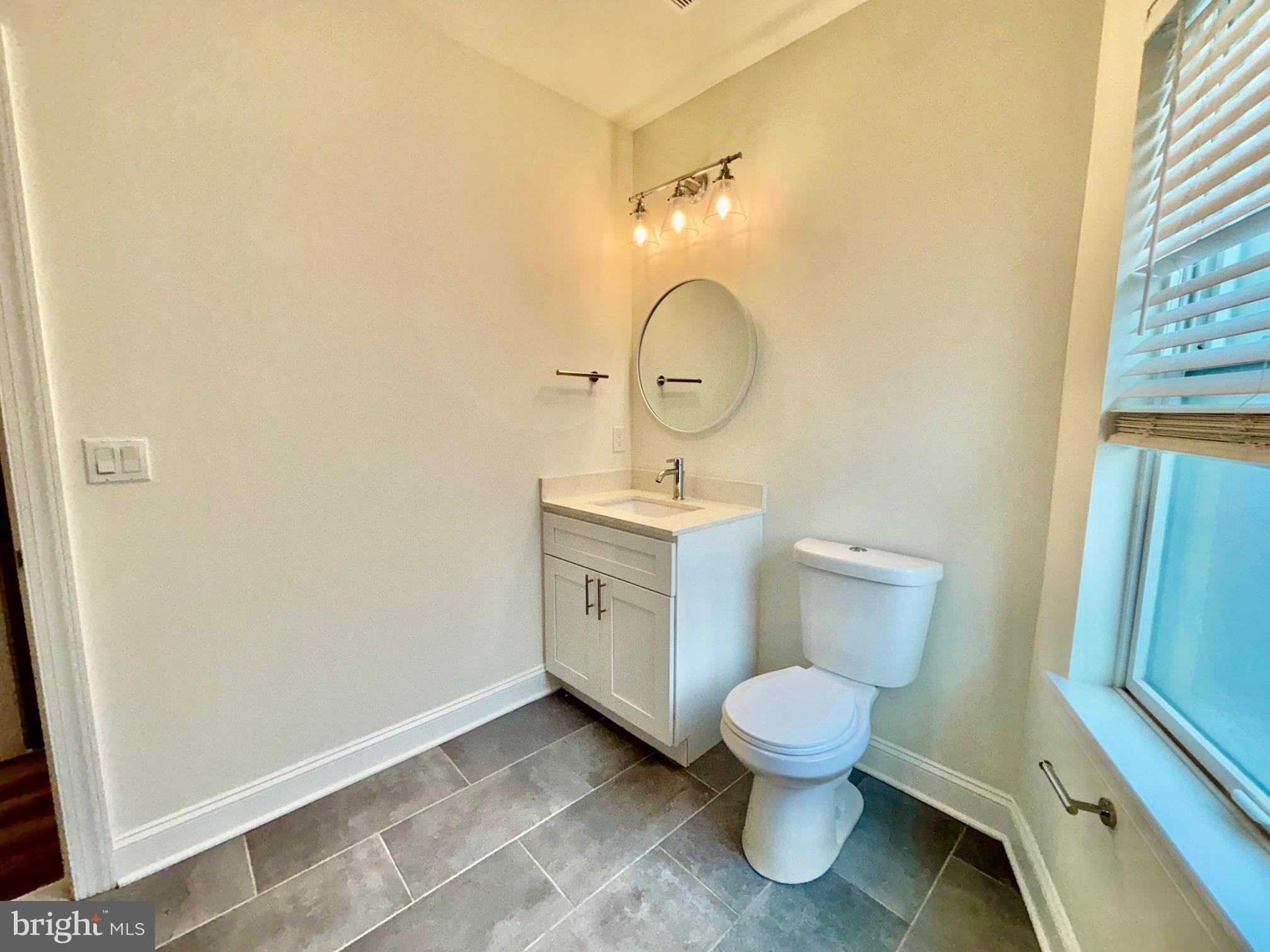 6601 Ridge Avenue, Unit D Philadelphia, PA 19128 - Photo 6 of 10 a bathroom with a toilet sink and mirror