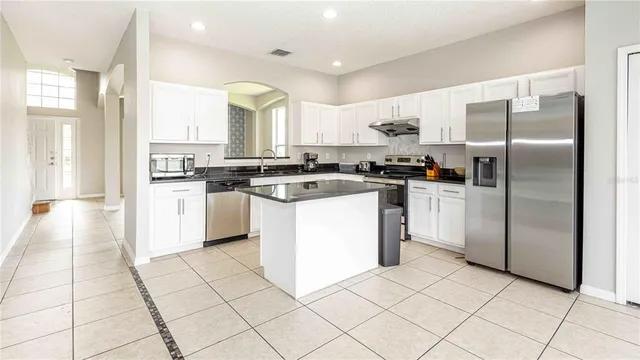 a kitchen with stainless steel appliances granite countertop a stove a sink and a refrigerator