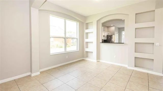 an empty room with windows and cabinet