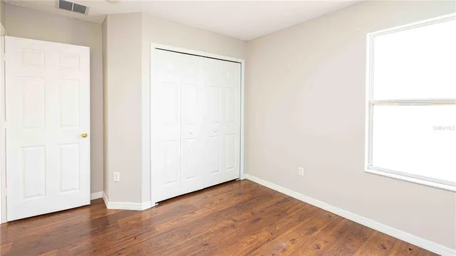 a view of an empty room with wooden floor
