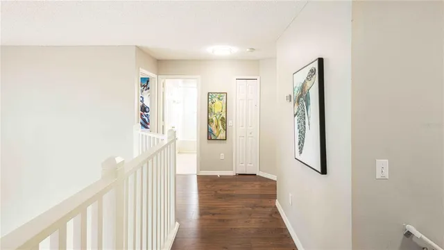 a view of a hallway with wooden floor and staircase