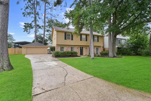 a front view of a house with a yard and trees