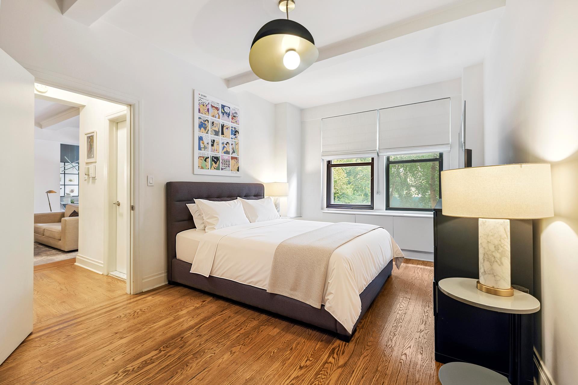 242 East 19th Street, Unit 2C Manhattan, NY 10003 - Photo 6 of 9 a bedroom with a bed and a chandelier