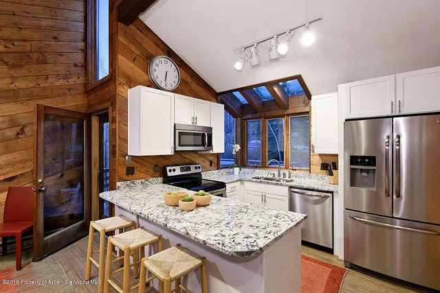 a kitchen with stainless steel appliances granite countertop a sink refrigerator and microwave