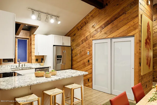 a kitchen with stainless steel appliances granite countertop a sink refrigerator and cabinets