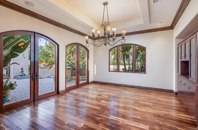 a bedroom with a large bed a flat tv screen and a dresser