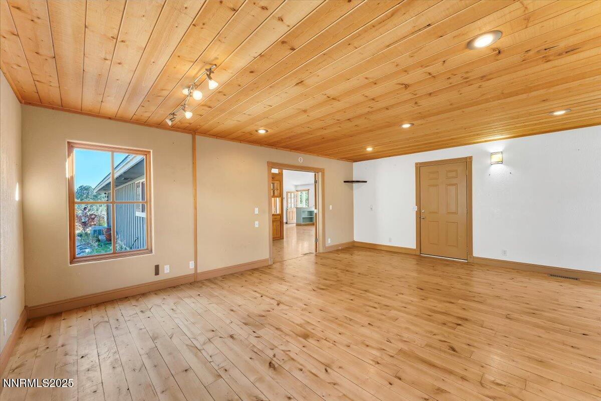21410 Sazarac Road Reno, NV 89521 - Photo 11 of 41 a view of an empty room with wooden floor and a window