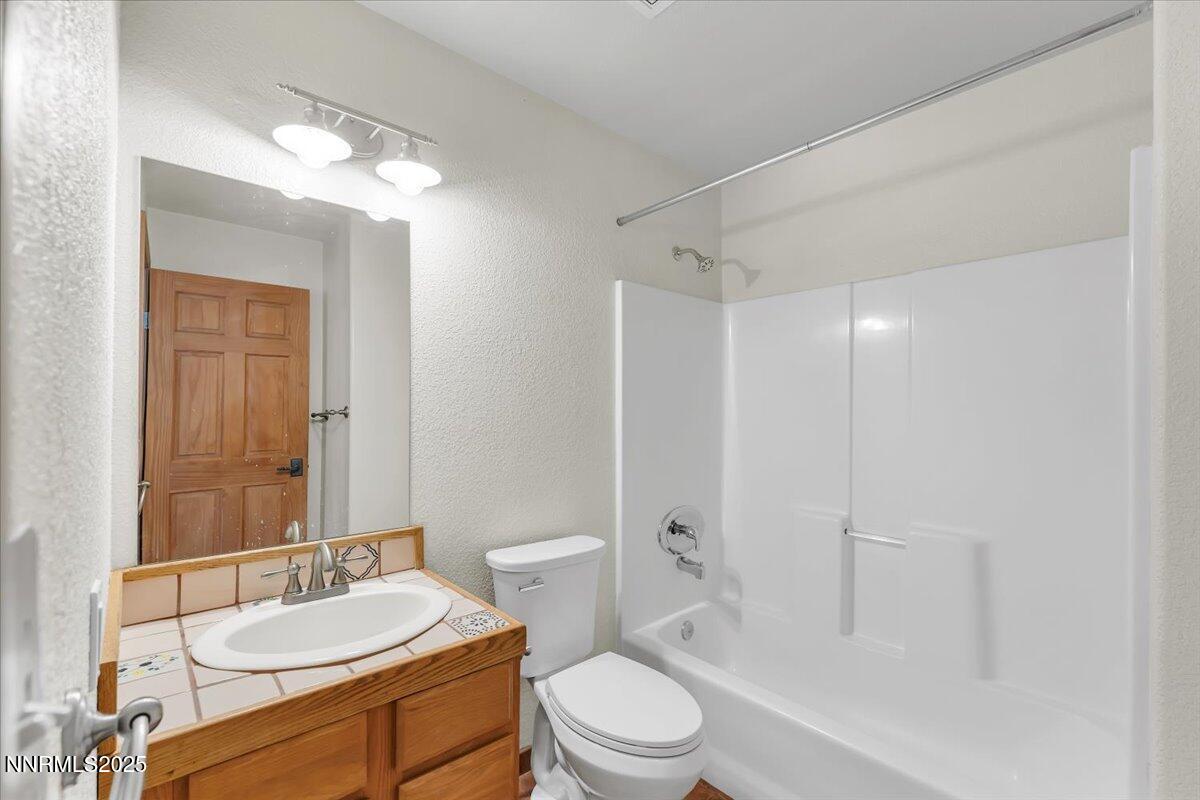 21410 Sazarac Road Reno, NV 89521 - Photo 18 of 41 a bathroom with a sink a toilet a mirror and shower