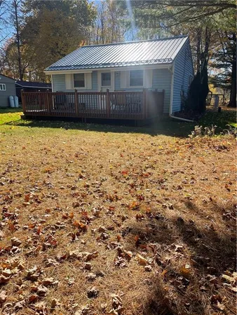 a view of a white house with large windows and a yard
