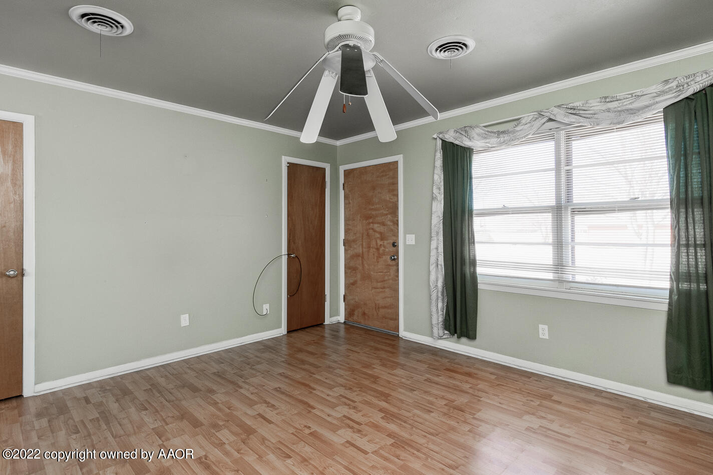 5015 South Milam Street Amarillo, TX 79110 - Photo 4 of 15 an empty room with wooden floor cabinet and windows