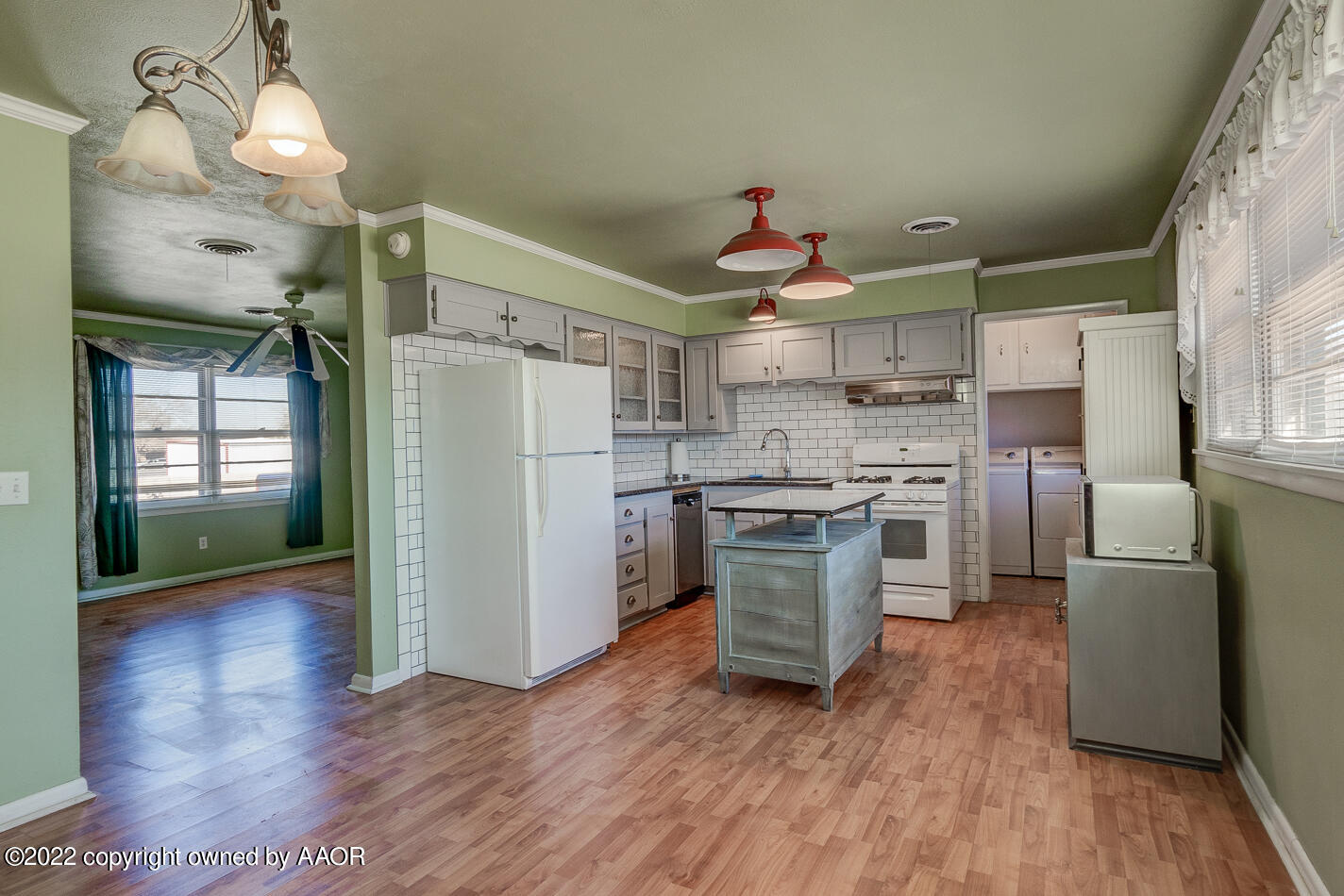 5015 South Milam Street Amarillo, TX 79110 - Photo 5 of 15 a kitchen with stainless steel appliances granite countertop a refrigerator a sink dishwasher a stove and a dining table with wooden floor
