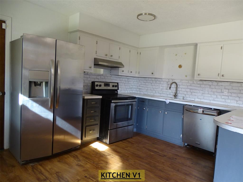 908 Brookside Street Sweetwater, TX 79556 - Photo 3 of 20 a kitchen with stainless steel appliances granite countertop a stove a sink and a refrigerator