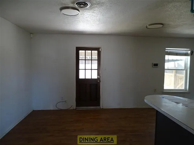 an empty room with wooden floor windows and closet