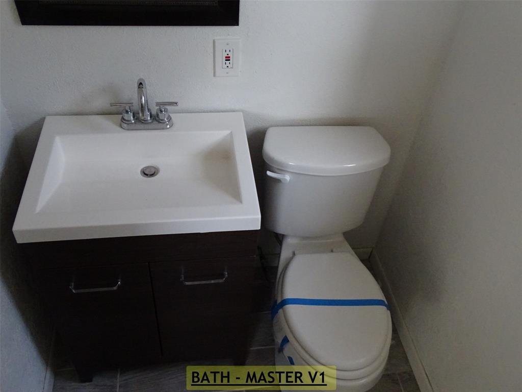 908 Brookside Street Sweetwater, TX 79556 - Photo 7 of 20 a bathroom with a toilet and a sink