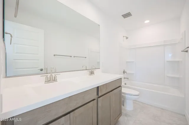 a bathroom with a granite countertop sink a toilet and bathtub