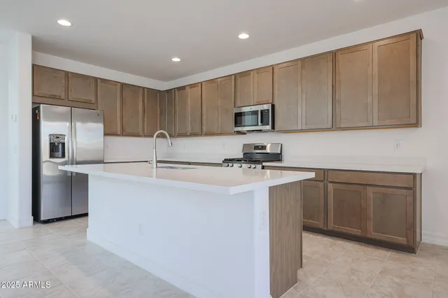 a kitchen with stainless steel appliances granite countertop a refrigerator sink and microwave