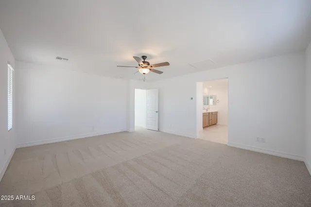 a view of an empty room with a chandelier fan