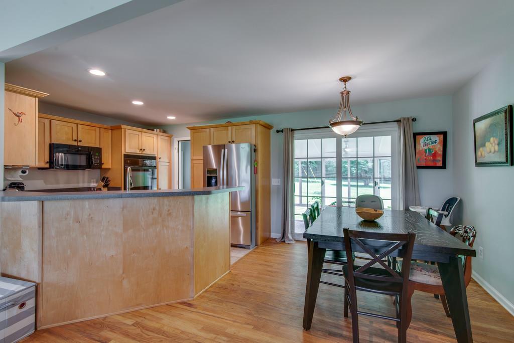1102 Center Point Road Hendersonville, TN 37075 - Photo 10 of 30 a kitchen with stainless steel appliances granite countertop a refrigerator a stove a sink dishwasher with a dining table and chairs with wooden floor