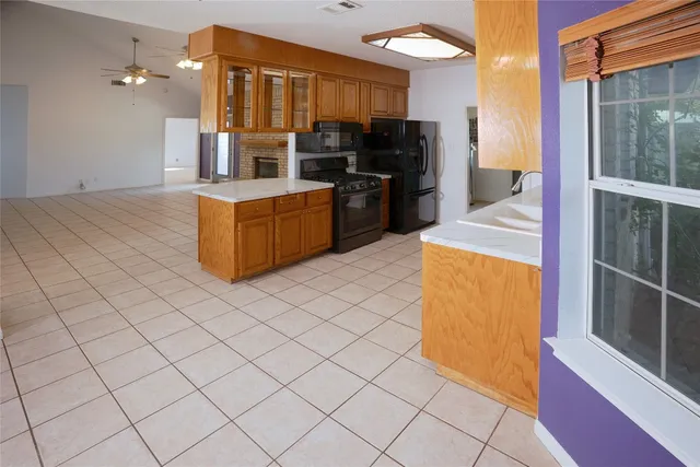 a large kitchen with stainless steel appliances a sink and a refrigerator