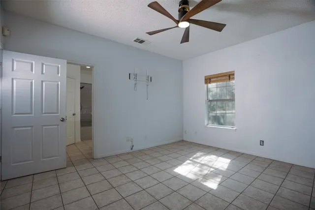 a view of empty room with window and ceiling fan