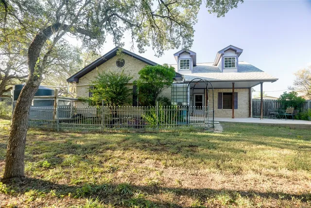 a view of a house with backyard and a tree