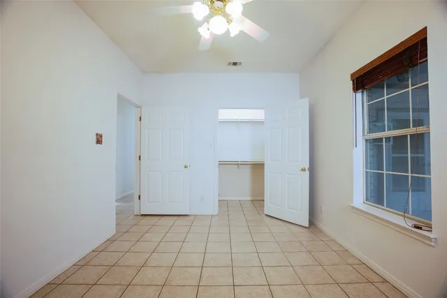 a view of an empty room with window and cabinet