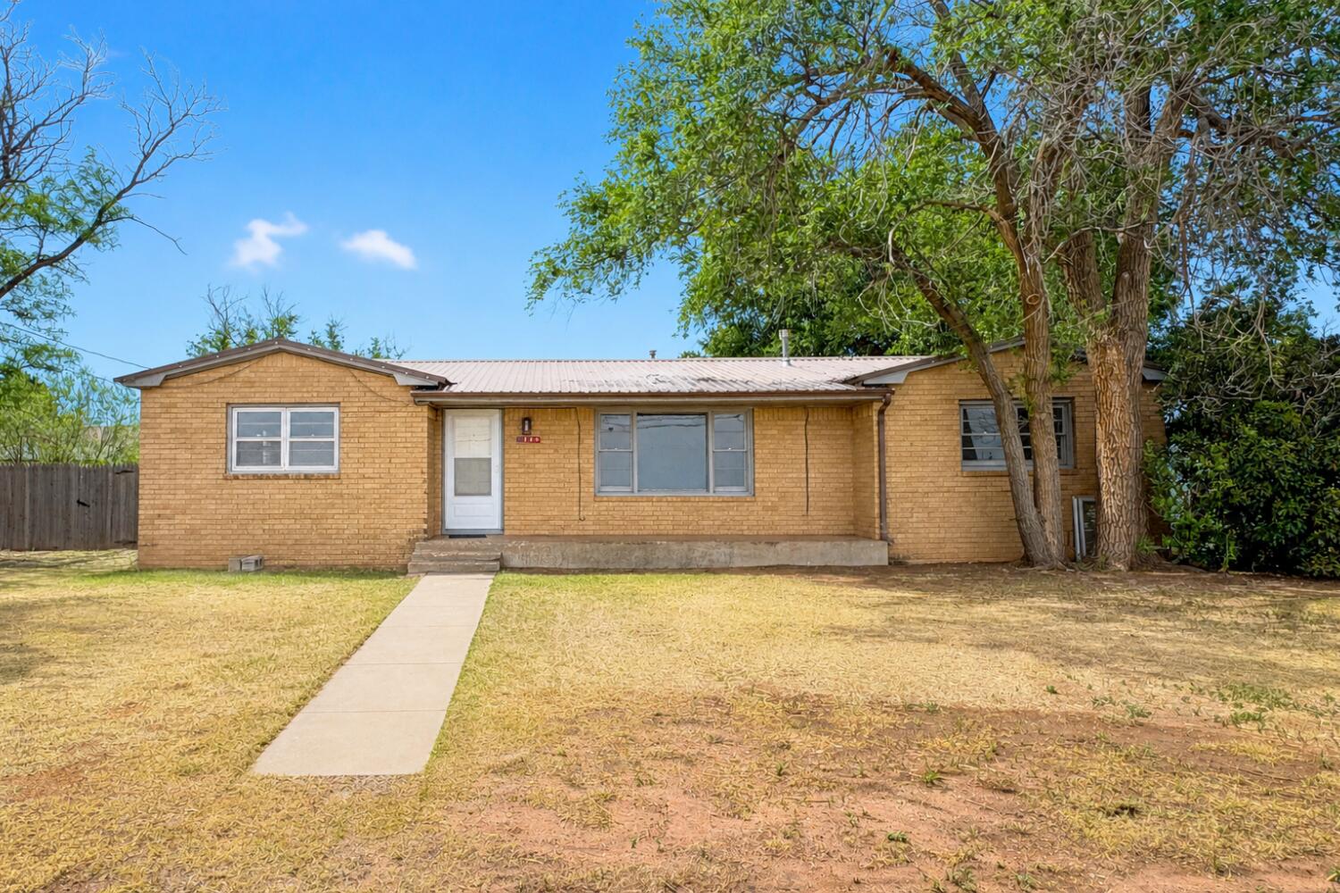 a view of a house with a backyard and a tree