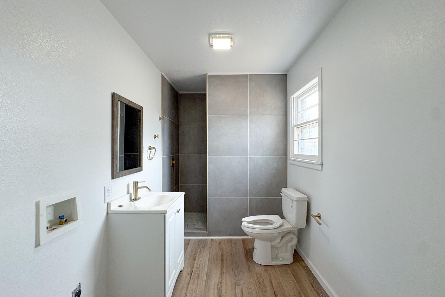 809 West 5th Street Wolfforth, TX 79382 - Photo 11 of 23 a bathroom with a toilet a sink and mirror