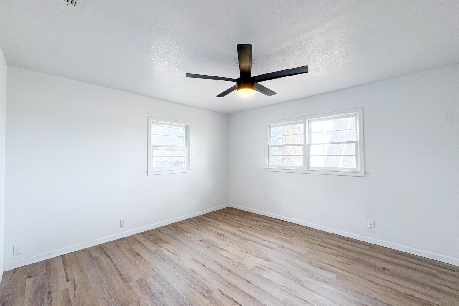 809 West 5th Street Wolfforth, TX 79382 - Photo 14 of 23 a view of empty room with wooden floor and fan