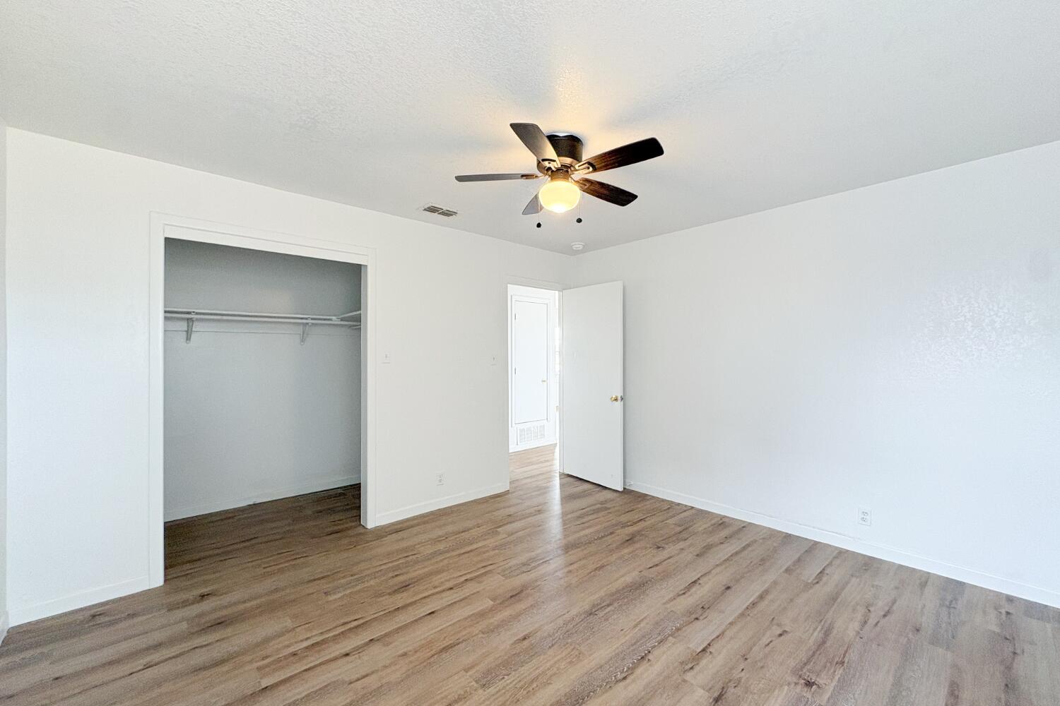 809 West 5th Street Wolfforth, TX 79382 - Photo 19 of 23 a view of a big room with wooden floor and a ceiling fan
