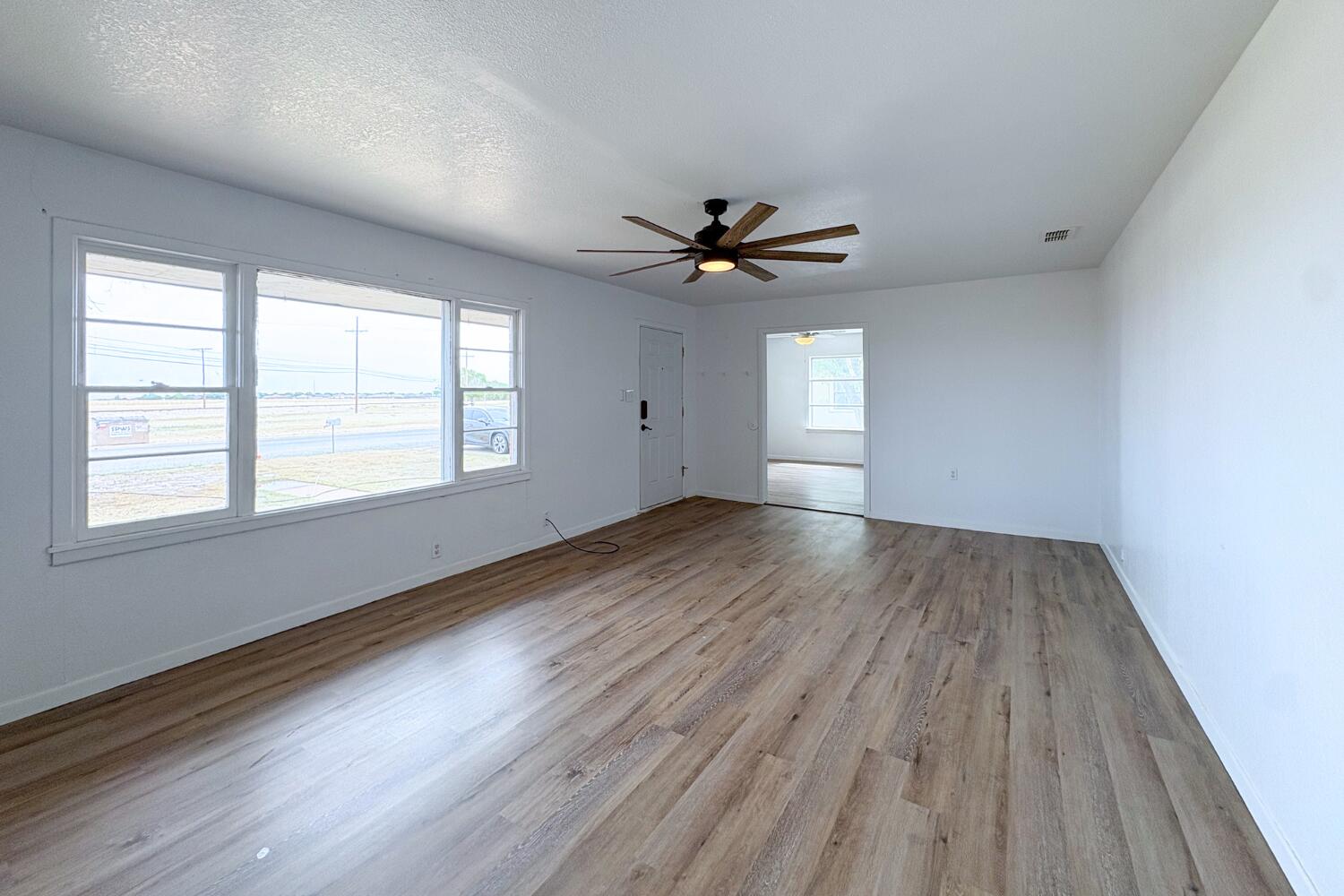 809 West 5th Street Wolfforth, TX 79382 - Photo 3 of 23 wooden floor in an empty room with a window
